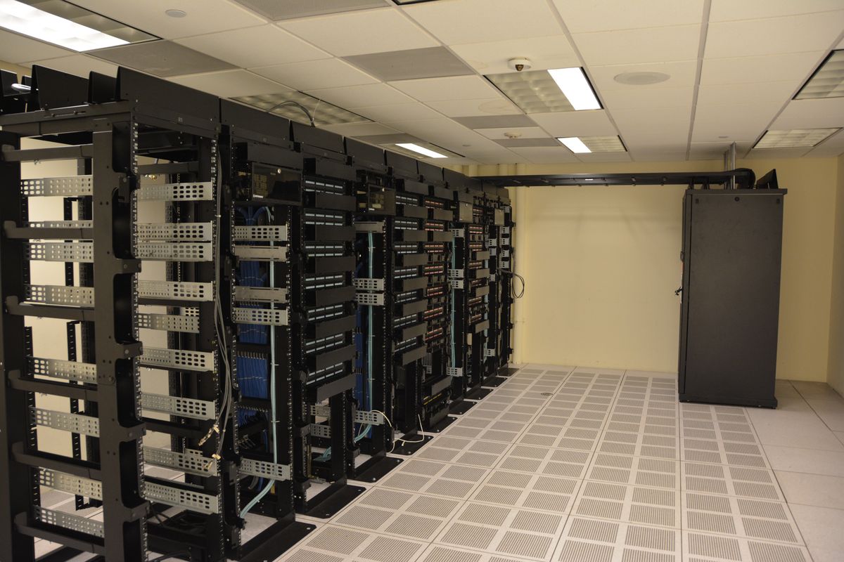 Rows of network switches and server racks in a data hall.